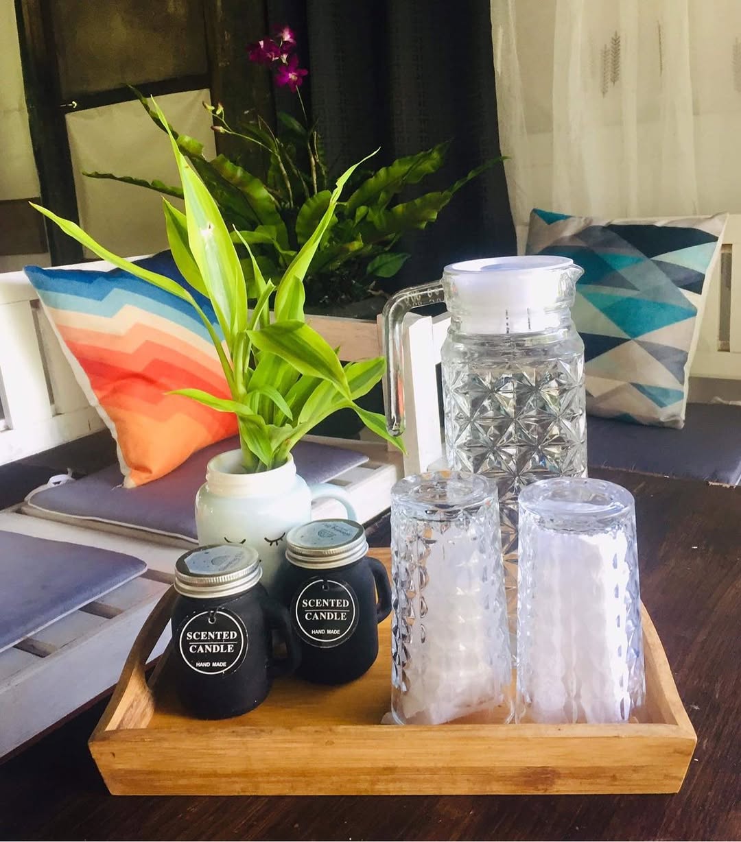 Dome interior detail — scented candles and glassware tray on a wooden surface inside the dome